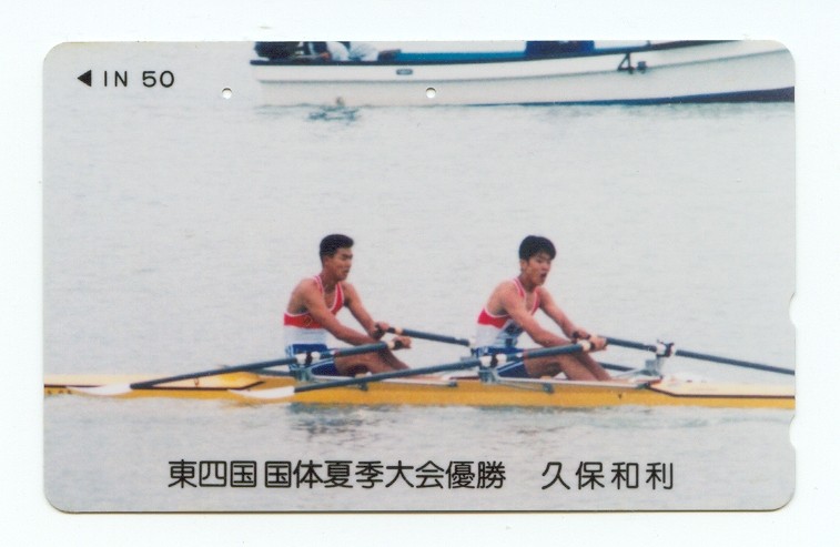 tc jpn 2x solo in yellow boat with motor launch in background 