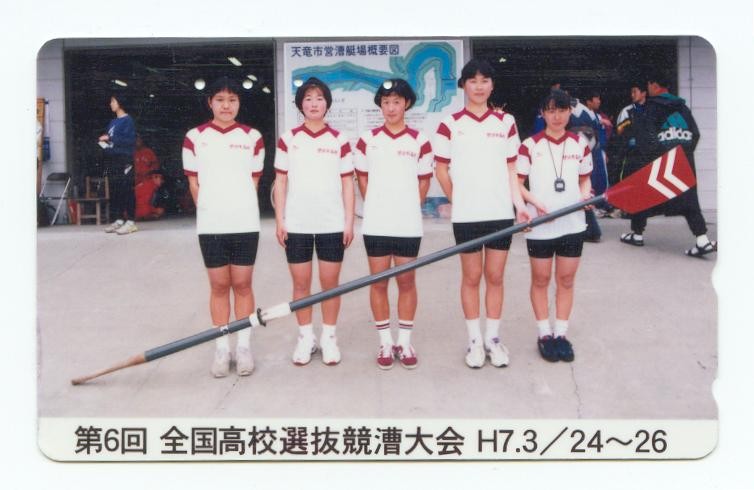 tc jpn jw4 crew posing behind oar with big blade coloured in red with white stripes 